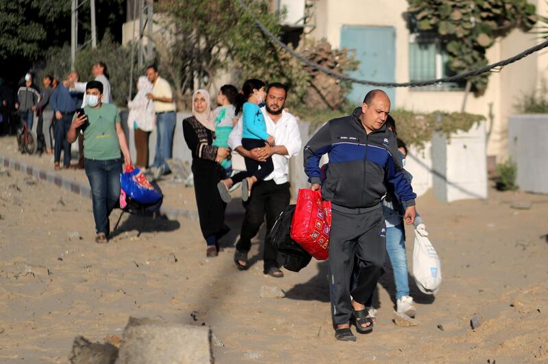 Palestinians evacuate after their tower building was hit by Israeli air strikes, in Gaza City. Reuters