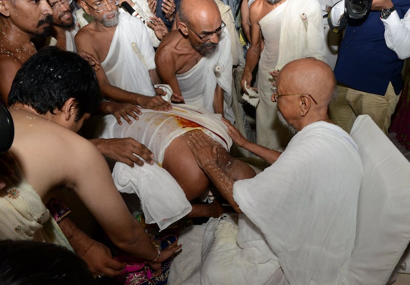 Millionaire Indian businessman Bhawarlal Doshi, centre, bends over in his new attire as he takes blessings from senior monks during a ceremony in the western city of Ahmedabad where he became a Jain monk in May 2016.