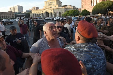 Armenian police officers detain a protester outside the government building in central Yerevan on August 8, 2023.  Armenian police on August 8, 2023 detained a dozen protesters, mostly war veterans, in central Yerevan after they blocked a government building, demanding authorities take steps to unblock the Lachin corridor, shut down by neighbour and foe Azerbaijan.  The Lachin corridor is the sole road linking the breakaway Armenian-populated region of Nagorno-Karabakh -- over which Yerevan and Baku fought two wars -- with Armenia.  (Photo by Karen MINASYAN  /  AFP)