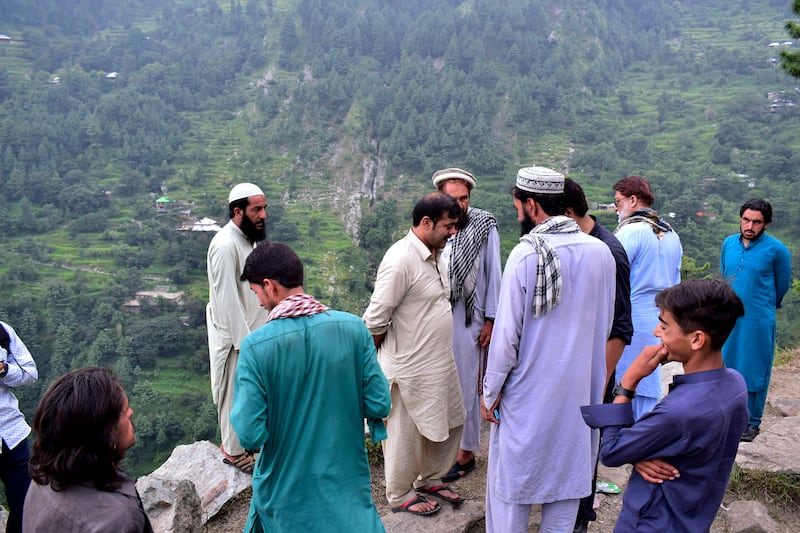 Local residents gather near the incident site, in Pashto village, a mountainous area of Battagram district. AP