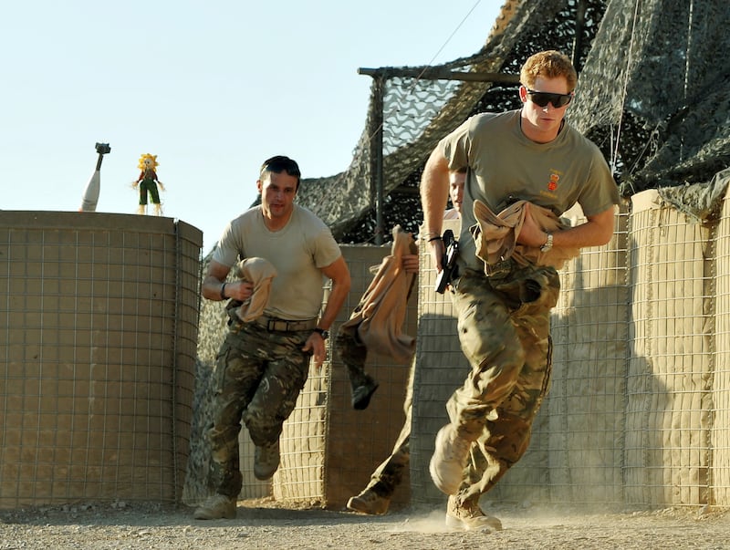 This picture taken on November 3, 2012 shows Britain's Prince Harry (R) running out of the VHR (very high ready-ness) tent to scramble his Apache with fellow Pilots at the British controlled flight-line at Camp Bastion in Afghanistan's Helmand Province, where he was serving as an Apache Helicopter Pilot/Gunner with 662 Sqd Army Air Corps. Britain's Prince Harry confirmed he killed Taliban fighters during his stint as a helicopter gunner in Afghanistan, it can be reported after he completed his tour of duty on January 21, 2013.  AFP PHOTO / POOL / JOHN STILLWELL (Photo by JOHN STILLWELL / POOL / AFP)
