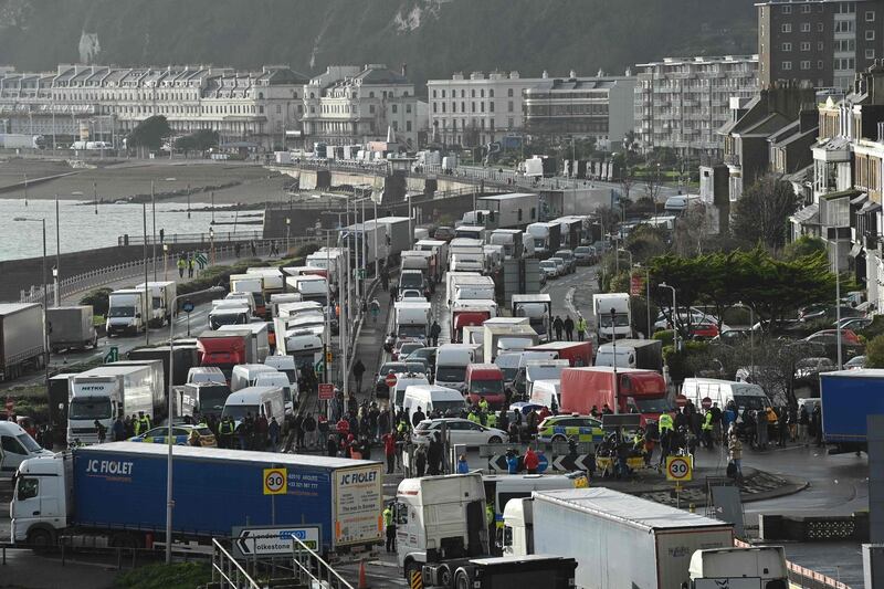 Drivers stand with their HGV freight lorries blocking the entrance trying to enter the port of Dover in Kent, south east England, on December 23, 2020, that is still cordoned after the UK and France agreed a protocol to reopen the border to accompanied freight arriving in France from the UK requiring all lorry drivers to show a negative Covid-19 test.  France and Britain reopened cross-Channel travel on Wednesday after a 48-hour ban to curb the spread of a new coronavirus variant but London has warned it could take days for thousands of trucks blocked around the port of Dover to get moving.
 / AFP / JUSTIN TALLIS
