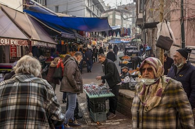 A street vendor speaks with potential customers on a retail street in Bursa, Turkey, on Tuesday, Jan.  4, 2022. Bloomberg