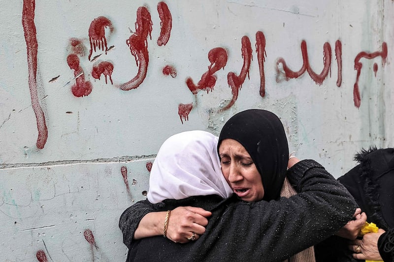 Women embrace near Ibn Sina Hospital as mourners carried the dead men through the streets. AFP
