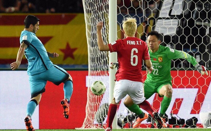 Luis Suarez scores a goal past Guangzhou Evergrande goalkeeper Li Shuai. Toshifumi Kitamura / AFP