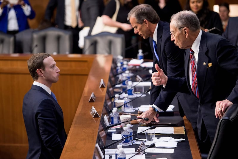 Facebook CEO Mark Zuckerberg speaks with Senator John Thune and Senator Chuck Grassley following a joint hearing of the Senate Commerce, Science and Transportation Committee and Senate Judiciary Committee. Brendan Smialowski / AFP