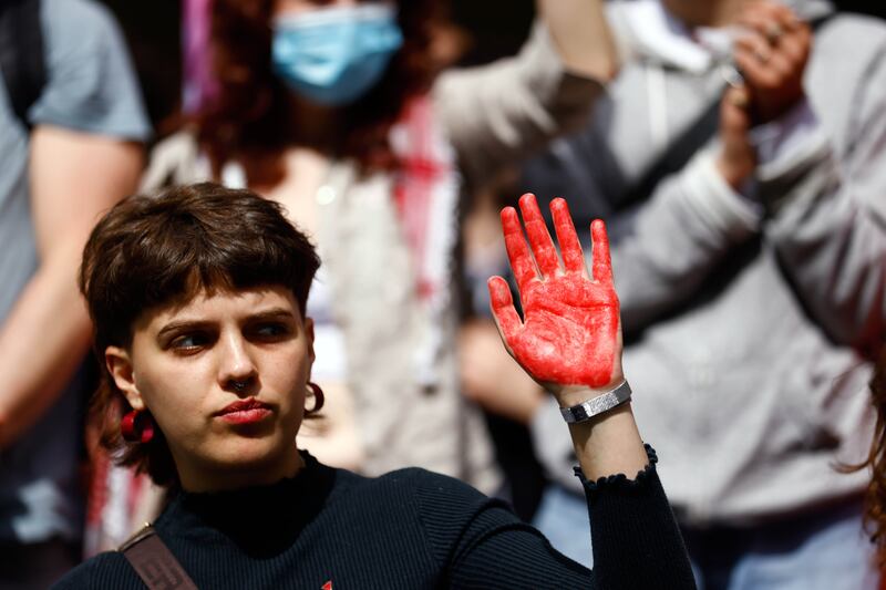 A demonstrator shows her red-painted hand. EPA