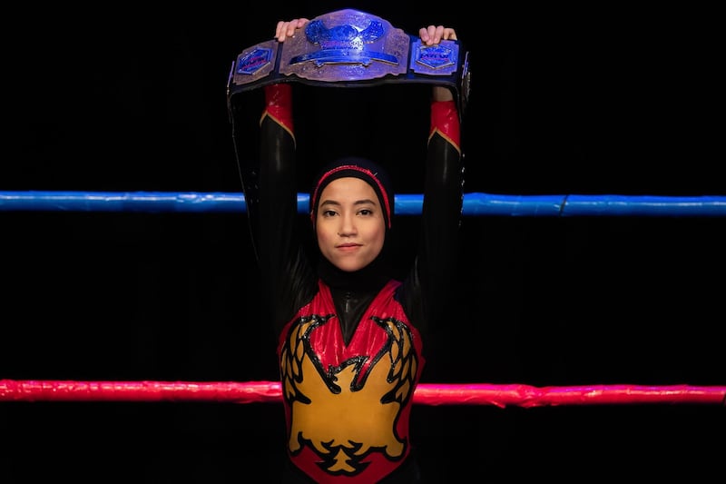 Hijab-wearing Malaysian wrestler Nor "Phoenix" Diana holds the Wrestlecon championship belt after winning a match against male opponents organised by Malaysia Pro Wrestling in Kuala Lumpur in July 2019. All pictures by AFP