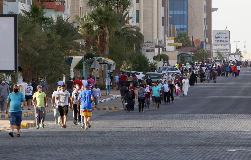 Mask-clad residents walk in a neighbourhood of Kuwait City.  AFP