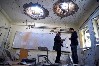 Journalists stand inside of a damaged classroom at the National Legal Training centre a day after gunmen stormed the university in Kabul on November 3, 2020. - Stunned students demonstrated outside Kabul University on November 3 after at least 22 people were killed in a brutal, on-campus attack claimed by the Islamic State group. (Photo by Wakil KOHSAR / AFP)