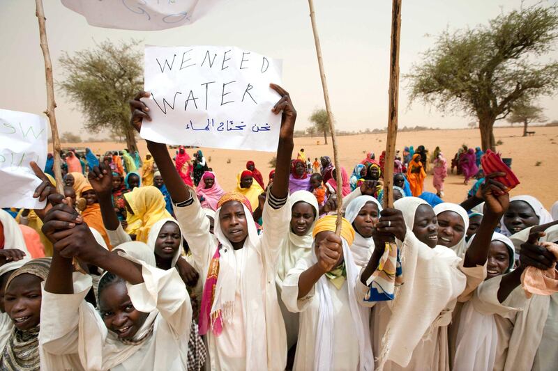 A handout picture released by the United Nations-African Union Mission in Darfur (UNAMID) shows Sudanese girls holding a sign reading "We need water" as they greet a UNAMID delegation in Forog, north Darfur, on May 30, 2012. Residents say the area, currently controlled by the Abdul Wahid faction of the rebel Sudan Liberation Army (SLA), is suffering from a serious shortage of water and medical supplies. AFP PHOTO/UNAMID/ALBERT GONZALEZ FARRAN
== RESTRICTED TO EDITORIAL USE - MANDATORY CREDIT "AFP PHOTO/UNAMID/ALBERT GONZALEZ FARRAN" - NO MARKETING NO ADVERTISING CAMPAIGNS - DISTRIBUTED AS A SERVICE TO CLIENTS == (Photo by ALBERT GONZALEZ FARRAN / AFP)