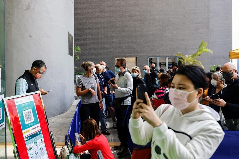 People queue up at a vaccination centre in Hong Kong, China, after work was temporarily suspended because of packaging defects in a single batch of Pfizer/BioNTech vaccines. Reuters