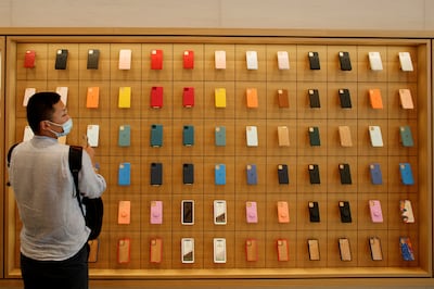 A man stands in front of a wall of iPhones cases in the Apple flagship store in Beijing. Reuters