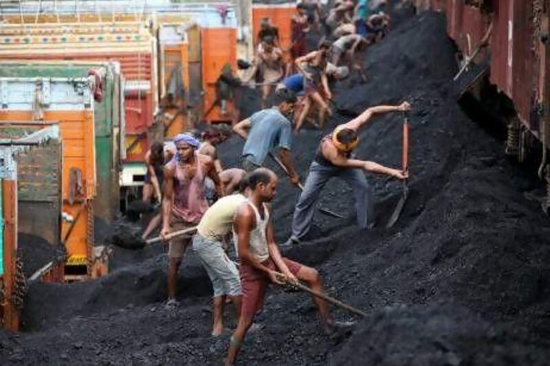 Indian labourers load coal onto trucks at a coal depot on the outskirts of Jammu, India. India's opposition has demanded Prime Minister Manmohan Singh resign after an audit found the government lost huge sums of money by selling coal fields without competitive bidding.
