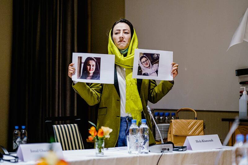 Delegate Heda Khamoush holds photos of women's rights activists held in Afghanistan during a meeting of Afghan civil society representatives in Oslo, Norway.. EPA