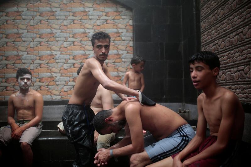 A staff scrubs a man at traditional Turkish bath after reopening for the public following lockdown restriction ease in Sana'a, Yemen. AP Photo