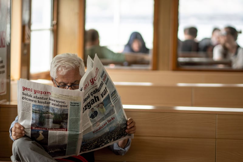 A passenger reads a newspaper on a ferry across the Bosphorus in Istanbul. Bloomberg