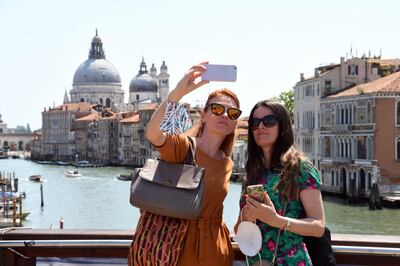 Tourists take selfie pictures on the Ponte dell'Accademia bridge over the grand canal in Venice on June 03, 2021. / AFP / ANDREA PATTARO
