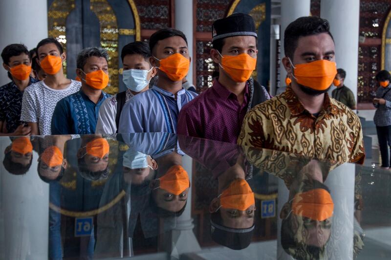 Indonesian Muslims wear masks as they queue to attend Friday Prayers amid the coronavirus pandemic, at a mosque in Surabaya, East Java, Indonesia.  EPA