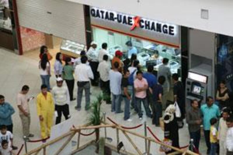 People line up at the Qatar-UAE money exchange at the City Centre-Doha mall in Doha, Qatar on March 28, 2008.