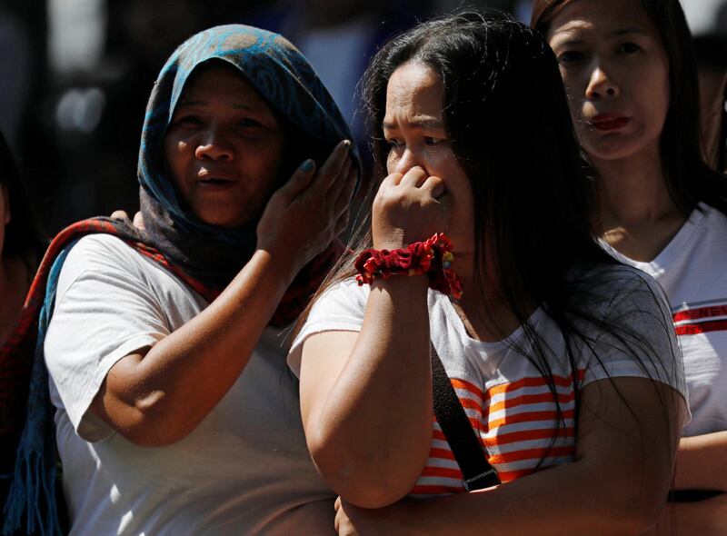 Onlookers react as rescuers attempt to reach survivors. Reuters