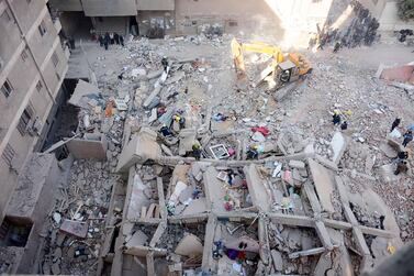 People gather around the rubble of a building that collapsed in the popular area of Gesr Suez, east of the Egyptian capital Cairo. AFP