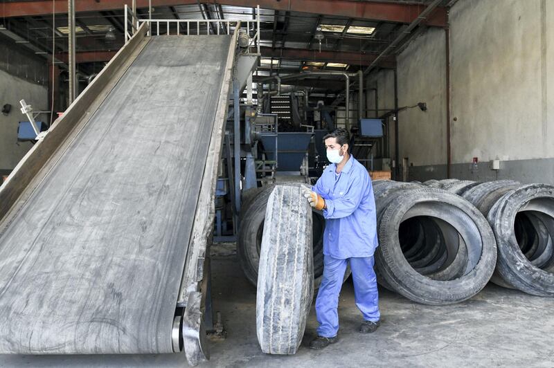 Abu Dhabi, United Arab Emirates - The worker places the used tire on the belt for shredding, and purification process to begin at the Gulf Rubber factory in Al Ain. Khushnum Bhandari for The National