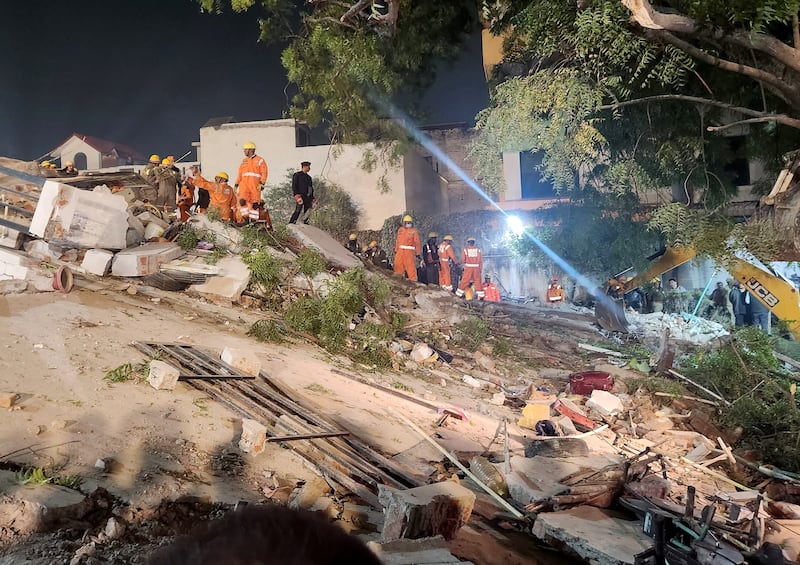 Rescue workers on the debris of the collapsed building in Lucknow on Tuesday.  Reuters