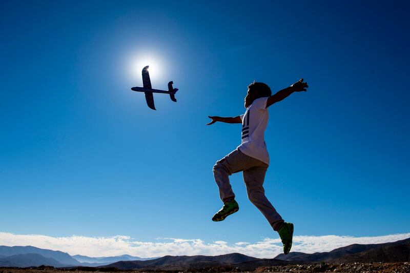 A boy plays with a toy plane on the eve of a solar eclipse, in La Higuera, Coquimbo Region, in the Atacama desert about 580km north of Santiago.  AFP