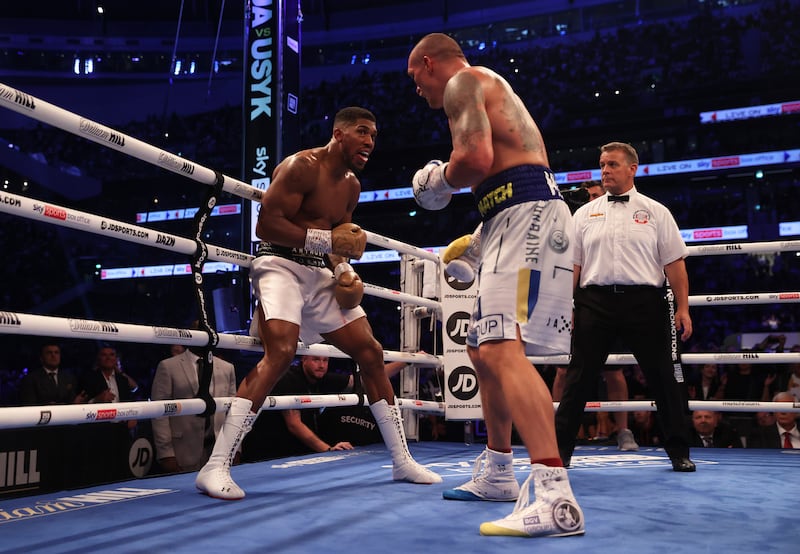 Oleksandr Usyk punches as Anthony Joshua ducks. Getty Images