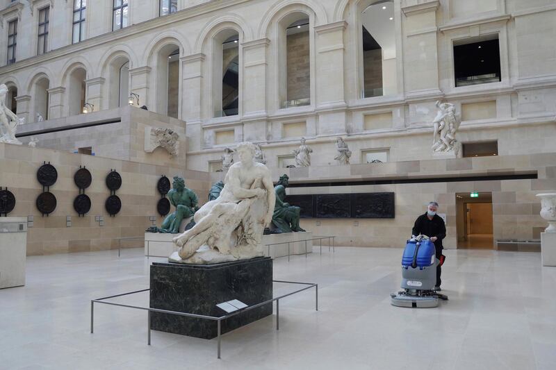 A worker cleans the Marly courtyard in the Louvre on February 11, 2021. AP