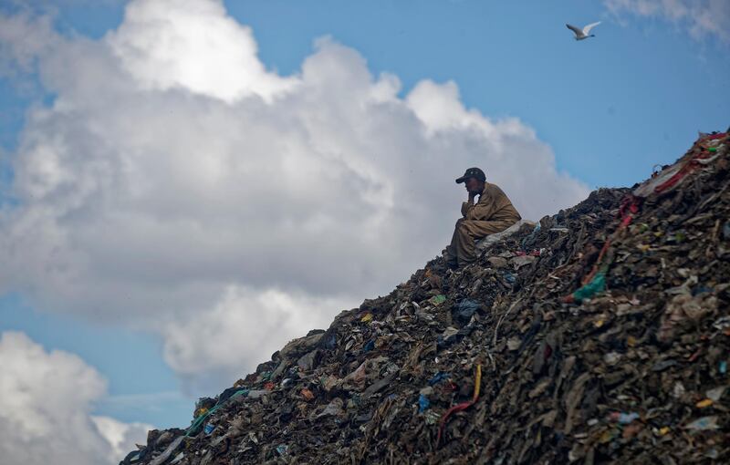 A man takes a break on top of a hill of garbage at the dump in the Dandora slum of Nairobi, Kenya. AP Photo