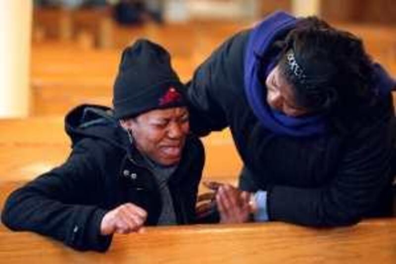 A woman is comforted as she prays for the victims of an earthquake that hit Haiti at St Jerome's Church in the East Flatbush section of Brooklyn, New York January 13, 2010. REUTERS/Jessica Rinaldi (UNITED STATES - Tags: DISASTER SOCIETY RELIGION IMAGES OF THE DAY) *** Local Caption ***  NYC303_QUAKE-HAIITI_0113_11.JPG