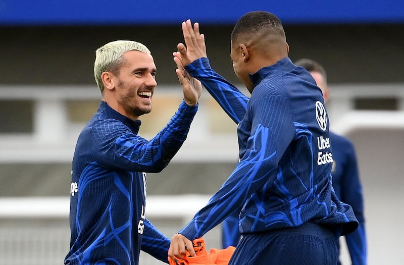 Antoine Griezmann, left, high-fives Kylian Mbappe. AFP