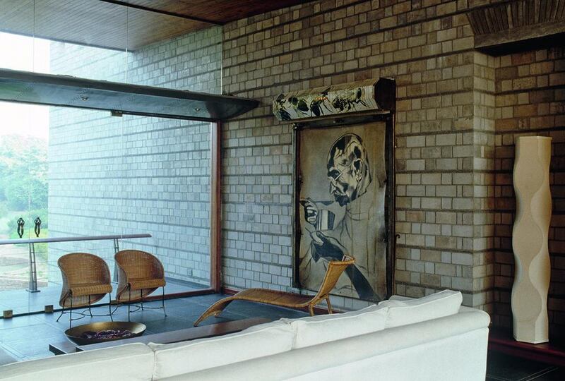 White sofa facing floor to ceiling window in modern sitting room.