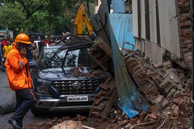 Rescue worker speaks on phone at site of residential building partial collapse in Mumbai on Sunday. AP