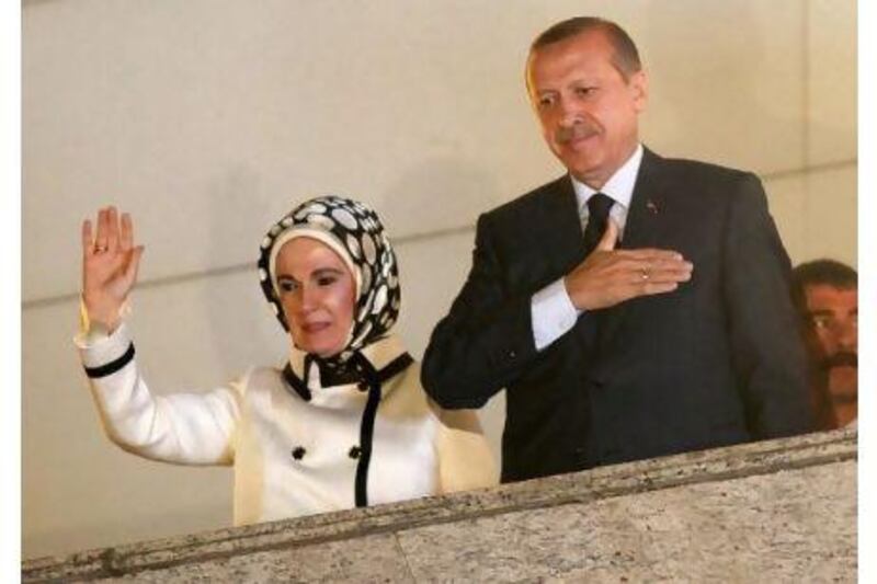 Turkey's prime minister, Recep Tayyip Erdogan, accompanied by his wife Emine Erdogan, greets his supporters at the AK Party headquarters in Ankara. Umit Bektas / Reuters