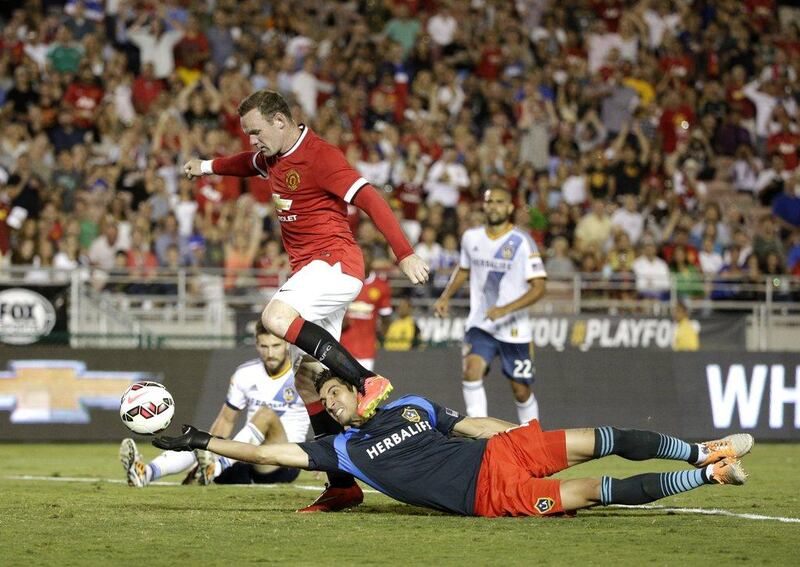 Wayne Rooney of Manchester United dribbles over LA Galaxy goalkeeper Jaime Penedo to score a goal in United's 7-0 friendly win over the MLS side on Wednesday night. AP Photo