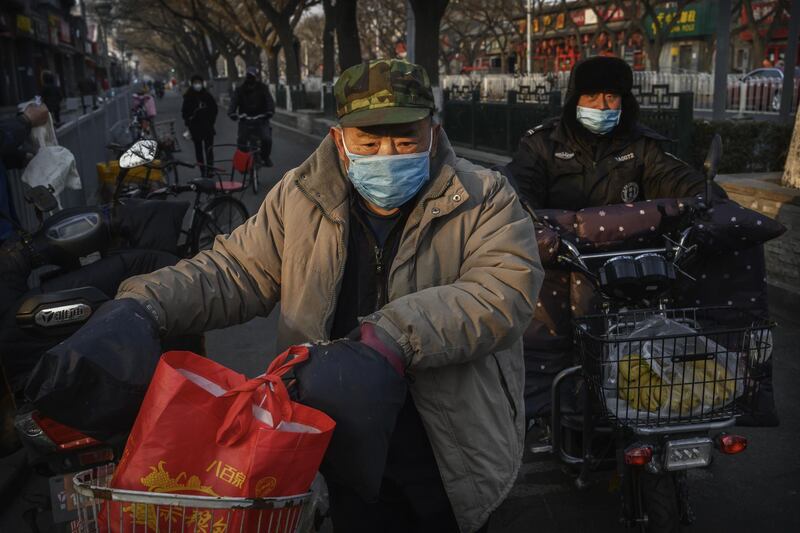 BEIJING, CHINA - FEBRUARY 19: Chinese men wear protective masks in a residential neighbourhood on February 19, 2020 in Beijing, China. The number of cases of the deadly new coronavirus COVID-19 rose to more than 58000  in mainland China Wednesday, in what the World Health Organization (WHO) has declared a global public health emergency. China continued to lock down the city of Wuhan in an effort to contain the spread of the pneumonia-like disease which medicals experts have confirmed can be passed from human to human. In an unprecedented move, Chinese authorities have maintained and in some cases tightened the travel restrictions on the city which is the epicentre of the virus and also in municipalities in other parts of the country affecting tens of millions of people. The number of those who have died from the virus in China climbed to over 2000 on Wednesday mostly in Hubei province, and cases have been reported in other countries including the United States, Canada, Australia, Japan, South Korea, India, the United Kingdom, Germany, France and several others. The World Health Organization has warned all governments to be on alert and screening has been stepped up at airports around the world. Some countries, including the United States, have put restrictions on Chinese travellers entering and advised their citizens against travel to China. (Photo by Kevin Frayer/Getty Images)