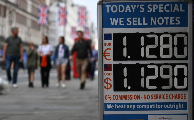 Pedestrians pass a currency exchange in London. EPA