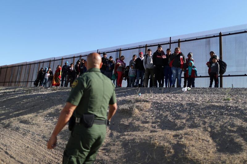 A group of Central American migrants surrenders to US Border Patrol Agent Jose Martinez south of the US-Mexico border fence in El Paso, Texas.  Reuters