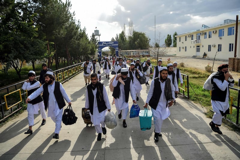(FILES) In this file photo taken on July 31, 2020 Taliban prisoners walk with their belongings as they are in the process of being potentially released from Pul-e-Charkhi prison, on the outskirts of Kabul. Almost two decades after the United States launched what would become its longest-ever war with air strikes on Afghanistan's ruling Taliban regime, the hardline group are in a stronger position than ever. The invasion on October 7, 2001 quickly toppled the militants, who had harboured Al-Qaeda, the group behind the September 11 attacks that killed nearly 3,000 people in America just weeks earlier.
 / AFP / WAKIL KOHSAR
