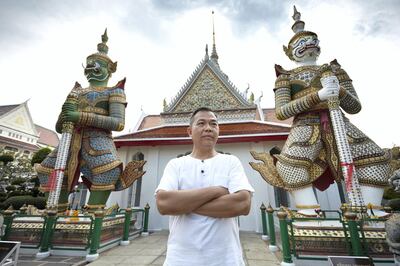 Bangkok-Thailand-Temple of dawn- Hartanto’s Portrait, standing in front of the two famous Guardian Giant statues at Wat Arun (the Temple of dawn). Sasamon Rattanalangkarn for The National