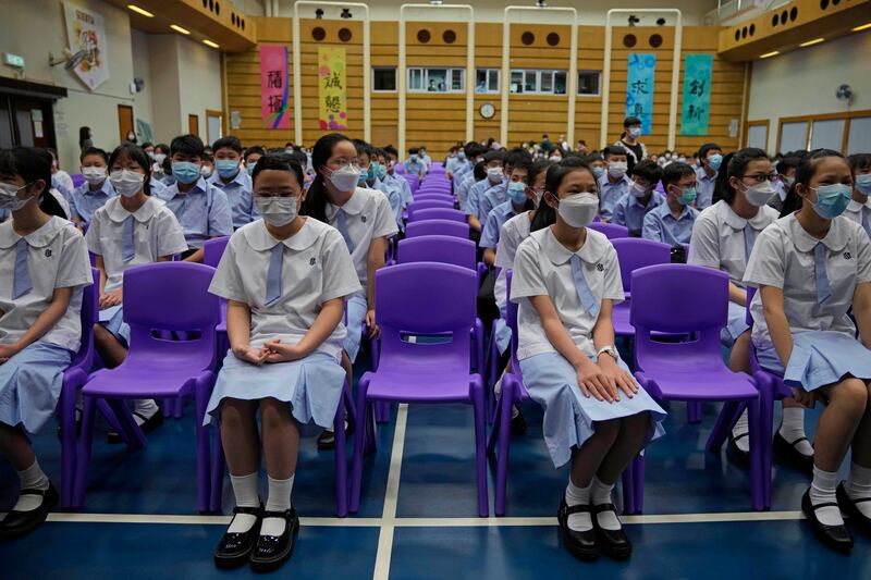 Students attend a Chinese national flag-raising ceremony. Visitors can now enter Hong Kong from the mainland without needing to quarantine. AP