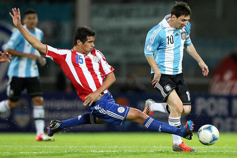 Paraguay's Victor Caceres (L) fights for the ball with Argentina's Lionel Messi during their World Cup's 2014 qualifying soccer match in Cordoba September 7, 2012.   REUTERS/Enrique Marcarian (ARGENTINA - Tags: SPORT SOCCER TPX IMAGES OF THE DAY)