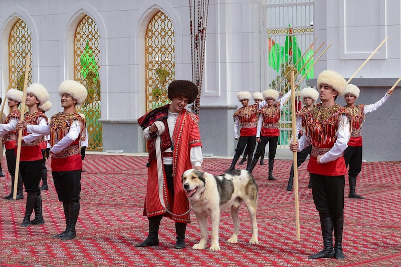 A man dressed in a national costume, centre, pets his border guard shepherd dog. President Gurbanguly Berdymukhamedov established the holiday to be observed on the same day that Turkmenistan lauds its Akhla-Teke horse, a breed known for its speed and endurance. AP Photo