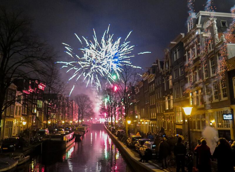 -FILE- In this Thursday Jan. 1, 2015, file image, fireworks explode at Bloemgracht during New Year celebrations in the center of Amsterdam. A year overshadowed by the coronavirus pandemic will not go out with the usual bang in the Netherlands after the Dutch government announced Friday, Nov. 13, 2020, it is banning the sale and use of most fireworks. (AP Photo/Margriet Faber)