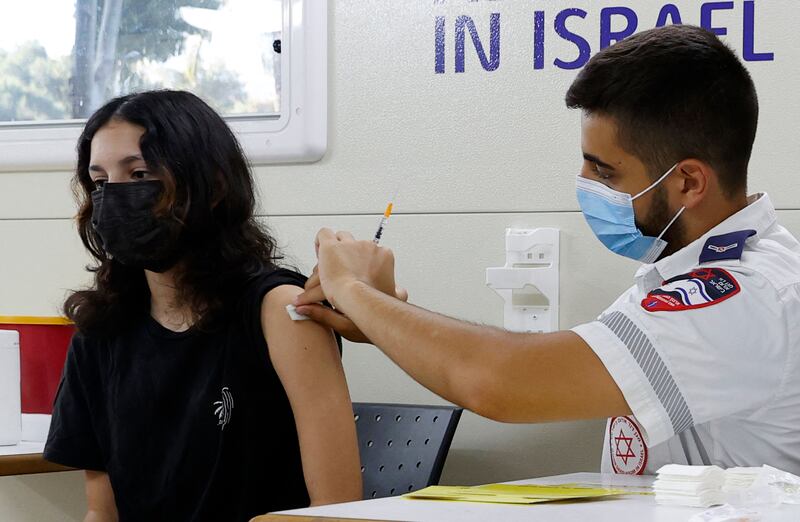 An Israeli girl receives a dose of the Pfizer/BioNTech Covid-19 vaccine from the Magen David Adom during a campaign to encourage the vaccination of teenager in Tel Aviv.