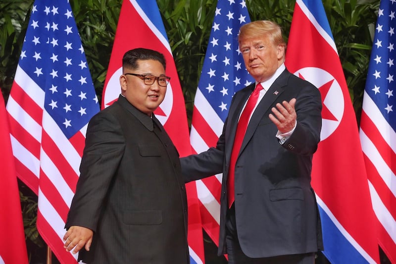 Mr Trump gestures towards photographers with North Korea leader Kim Jong-un. Kevin Lim / The Straits Times via AP