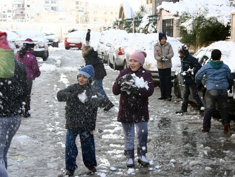 Children play with snow on January 10, 2013 in the Syrian capital of Damascus. Snow carpeted Syria's war-torn cities but sparked no let-up in the fighting, instead heaping fresh misery on a civilian population already enduring a chronic shortage of heating fuel and daily power cuts.  AFP PHOTO   / LOUAI BESHARA


